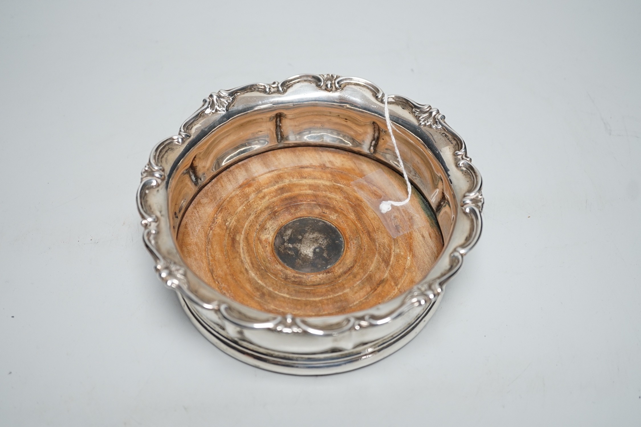 An early Victorian silver mounted wine coaster, with scrolling border, marks very rubbed, possibly London, 1838, diameter 16cm.
